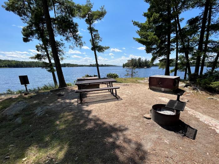 K17 View looking out from campsite core of the fire ring picnic table bear lockers and back of campsite sign overlooking the water.