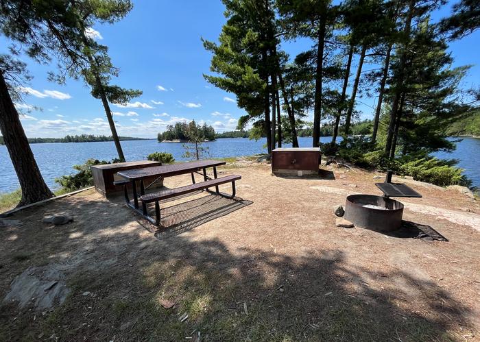 K17 View of campsite core overlooking the water of the fire ring bear lockers and picnic table.