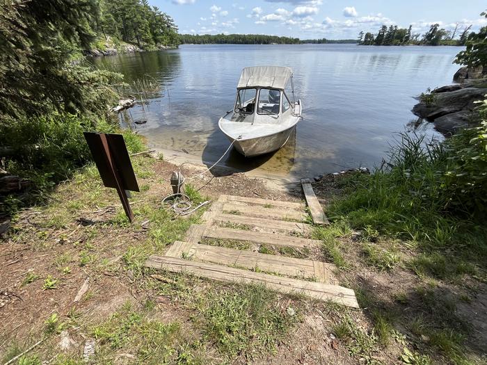 K24 View of the sand landing from shore looking down the stairs to the boat tied to a mooring post.