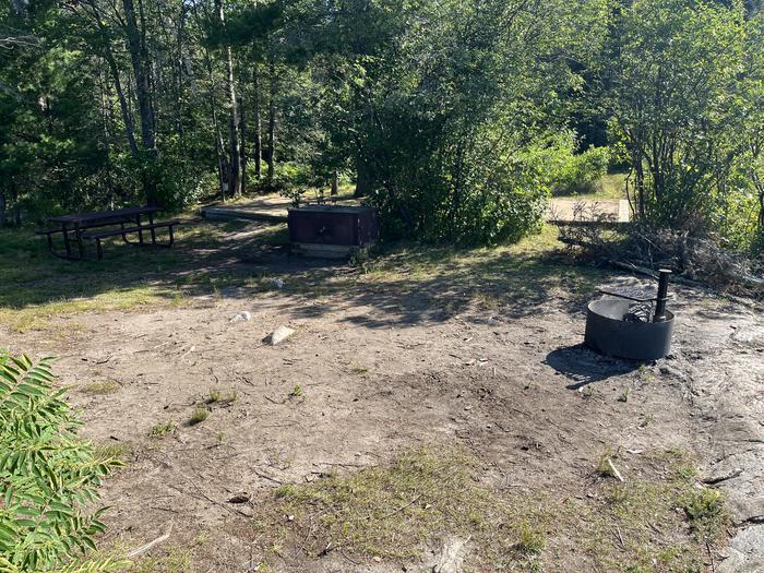 K29 View looking into campsite core of the fire ring bear locker picnic table and a couple of tent pads in the background.